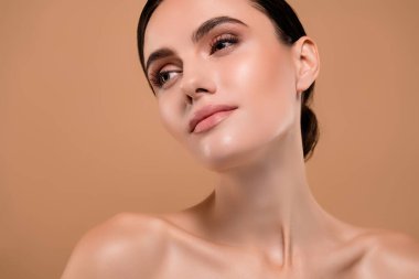 Pastel arka planda izole edilmiş, sağlıklı cilde sahip, çekici, çekici bir bayanın yakın plan fotoğrafı..