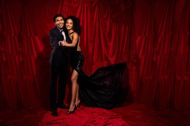 Çekici bir çiftin kırmızı kumaş arka planda izole bir şekilde sahnedeki tango dansının fotoğrafı..