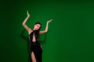 Süslü, kibar bir bayanın stüdyo portresi. Özel giyinmiş, dans eden, izole yeşil arka plan..