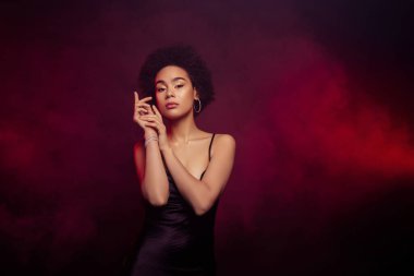 Şık, zarif bir kızın fotoğrafı yumuşak tenli kollar siyah elbiseler giyiyor tutkulu bir şekilde flört ediyor..