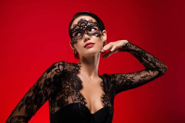 Seksi genç kızın fotoğrafı boş görünüyor. Dokunma boynu dantelli siyah maske kraliçesi kılık değiştirmiş kırmızı arka plan..