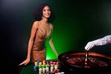 Kumarhane kulübünde fotografta muhteşem mutlu bir kız döner tekere dokunuyor ve VIP kulübü neon filtresi ile servet yapmaya çalışıyor..