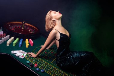 Yeşil poker masasına uzanmış pullu muhteşem bir kadının fotoğrafı VIP mekanında blackjack oynamaya geldi..