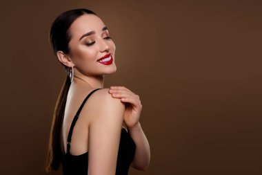 Siyah sutyen giymiş çekici bir kadının fotoğrafı. Cilt bakımının keyfini çıkar. Boş alan izole edilmiş bej rengi arka plan..