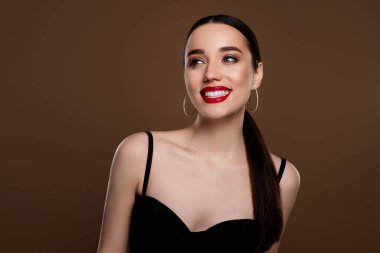 Tutkulu, parlak modelin fotoğrafı siyah elbise giy ve olayın tadını çıkar boş, izole edilmiş kahverengi arkaplan.
