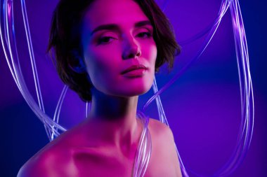 Çekici bir kızın fotoğrafı plastik kabloyla izole edilmiş neon filtre arka planının yanında görünüyor..