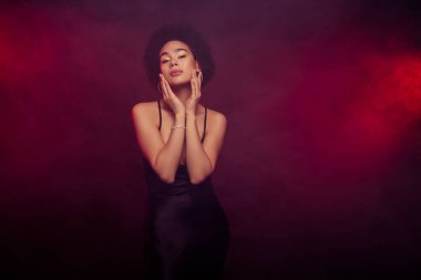 Burgonya rengi arka planda izole edilmiş, mutlu, çekici, çarpıcı ve şehvetli bir modelin fotoğrafı..