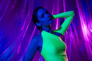 Güzel bir manken kızın fotoğrafı. Koluna dokunuyor. Başa dokunuyor..