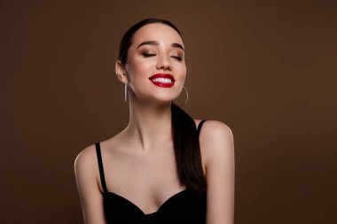 Tutkulu, parlak modelin fotoğrafı siyah elbiseler giy. Yeni yıl hediyeleri hayal et. Boş, izole, kahverengi arkaplan rengi..