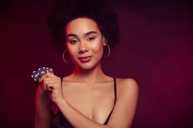 Çekici ve çekici kadın fişleri para kazanır. Şans koyu kırmızı arka planda izole edilir..