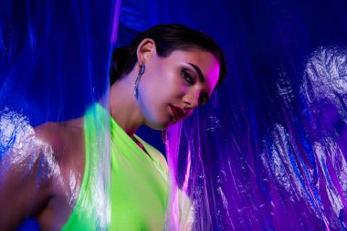 Yeşil elbiseli güzel, şık bir bayanın fotoğrafı. Ayırt edici bir şekilde izole edilmiş, açık renkli arka plan..