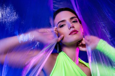 Kızın açık plastik perdeye dokunuşunun fotoğrafı. Tutkuyu hisset. İzole edilmiş canlı renk arkaplanı..