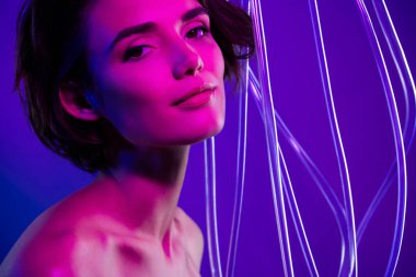 Çekici kızın fotoğrafı plastik tel kabloya yakın, izole edilmiş pembe neon rengi arka plan..