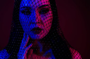 Göz kamaştırıcı güzel bir kadının fotoğrafı. Tutkulu bir flört. Koyu kırmızı arka planda izole edilmiş..