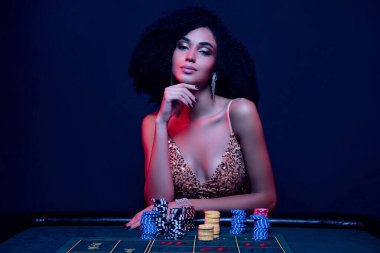 Çekici ve seksi kadın pokerinin fotoğrafı. Milyonlarca dolarlık bahis oynayıp beyin fırtınası yaparak zafer planı yaratıyor..