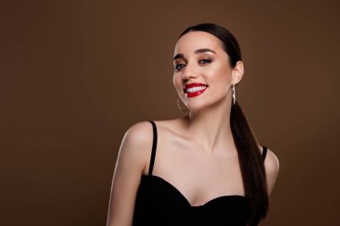 Siyahi sutyen giymiş çekici bir kadının fotoğrafı empirik alan izole edilmiş bej arka plan etkinliğini hazırlayın.