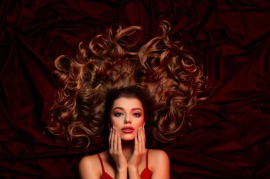 Kırmızı tekstil ipek arka planda izole edilmiş hassas, çekici, dokunaklı tenin yüksek açılı fotoğrafı..