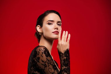 Muhteşem model kızın fotoğrafı boş uzay giysisi parlak kırmızı arka planda izole edilmiş dantel kıyafetler..