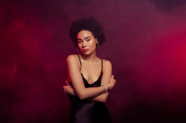 Göz kamaştırıcı güzellikteki kadının fotoğrafı. Koyu kırmızı arka planda izole edilmiş flörtün tadını çıkar..