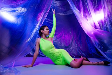 Güzel bir kadının poz verirken çekilmiş fotoğrafı. Kokteyl yeşil elbisesi, izole edilmiş stüdyo görüntüsü..