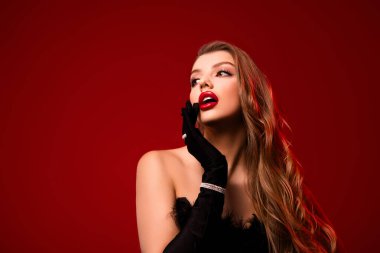 Parlak makyajlı muhteşem kadın dokunuşlu fotoğraf. Boş uzay kırmızı arka plan. Siyah eldiven önlük giyiyor..