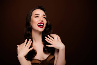 Neşeli, çekici bir bayan ünlünün fotoğrafı, kahverengi arka planda izole edilmiş boş bir alanda satışa sunuluyor..