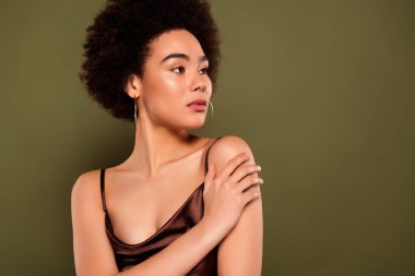 Göz kamaştırıcı bir kadının fotoğrafı. Kendine sarıl. Haki renk arka planında izole edilmiş boş bir alan..