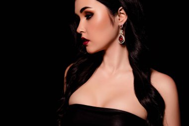 Model kadının kesilmiş portresi koyu kırmızı arka planda izole edilmiş pahalı mücevherler oluşturuyor..