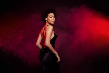 Çekici ve hassas modelin fotoğrafı koyu kırmızı arka planda izole edilmiş özel partiden keyif alıyor..