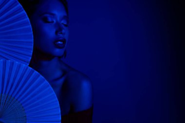 Japon kağıt fanatikleri tutan parlak hayalperest kadının fotoğrafı. Boş uzay mavi arka plan..