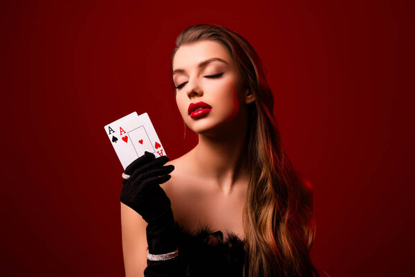 Tempting lady with closed eyes combinations with ace wear gown on red color background.