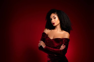 Kadife gecelikli çekici klas kız çapraz el ele tutuşarak kendine güvenen baştan çıkarıcı bakışlar atıyor..