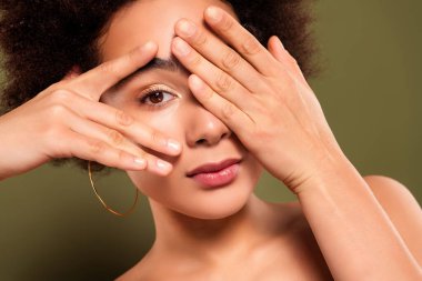 Haki rengi arka planda izole edilmiş oldukça çekici bir bayanın el kapağı göz makyajı prosedürünü kapat..