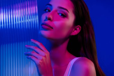 Duş jeli ürününü tanıtan muhteşem bir bayanın fotoğrafı. Mavi arka planda izole edilmiş..