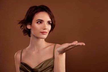 Güzel, genç bir bayanın el fotografı boş uzay giysisi modasına uygun kahverengi arka planda izole edilmiş haki rengi..