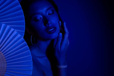 Çekici, güzel bir kadının, Çinli kağıt hayranlarının boş uzay rengi arka planında eğlendiği fotoğraf..