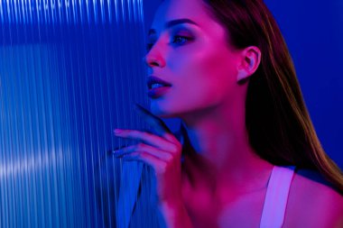 Göz kamaştırıcı bir bayanın fotoğrafı efektten keyif alıyor yüz gerdirme yöntemi mavi arka planda izole edilmiş..