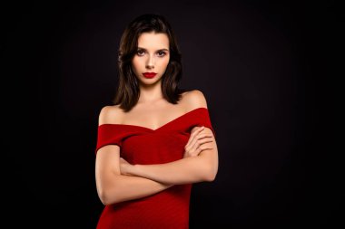 Şık kırmızı bir elbise giyen güzel esmer kadın, kararlı bir görünüm ve koyu bir zemin ile özgüvenli poz zarafet ve karizmayı vurguluyor.
