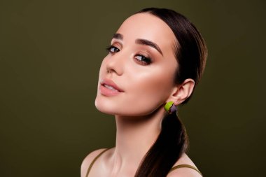 Renkli haki rengi arka planda kırmızı halısı olan güzel, narin, parlak bir kadının fotoğrafı..