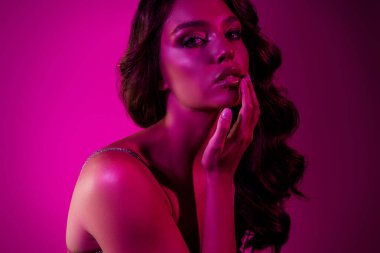 Zarif makyajlı ve pembe ışıkta parlayan parlak ciltli zarif genç bir bayan model. Güzelliği, kültürlülüğü ve çekiciliği yansıtan modaya uygun bir konsept..