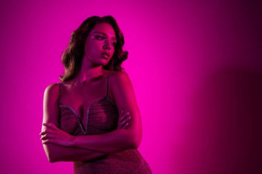 Güzel bir kadın canlı pembe bir arka plana karşı zarif bir şekilde poz verir. Güzellik, tarz ve cazibe sergiler. Moda, güzellik promosyonları ya da editör projeleri için mükemmel..