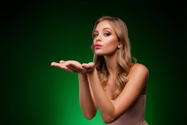 Zarif bir poz veren, zarif ve güzel bir bayan model, neşeli ve pozitif bir ruh hali sunuyor, canlı yeşil bir arka planda büyüleyici bir görünüm sergiliyor..