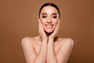 Muhteşem, mutlu, zarif, çıplak bir kadının fotoğrafı. Bej renkli arka planda izole edilmiş çıplak omuzlar..