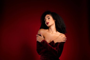 Zengin, çekici bir kız, gözleri kapalı, sarılıyor, yumuşak, kadife bir elbise giyiyor..