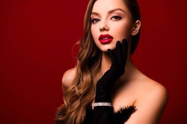 Flört eden kadının çekici bir dokunuş hissi... pürüzsüz cilt... kırmızı arka planda siyah eldiven bileziği takıyor..