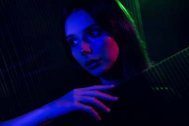 Genç bir kadının güzelliğini ve çekiciliğini vurgulayan atmosferik bir portre neon ışıklarının altında zarafeti ve sofistike bir gece kulübü havasını vurguluyor..