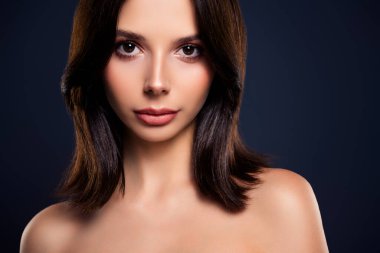 Genç ve çekici esmer bir kadının yakın plan fotoğrafı. Doğal güzelliği, pürüzsüz cildi ve şehvetli bir ifadeyi gösteriyor..