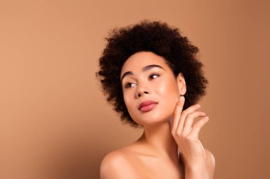 Hassas, nazik bir bayanın fotoğrafı. Sağlıklı cilt reklamları, bej renkli arka planda izole edilmiş cilt bakım ürünleri..