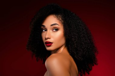 Dalgalı kıvırcık saçlı çekici şık bayan metin reklamları için arkaplan boşluğuna bakıyor..