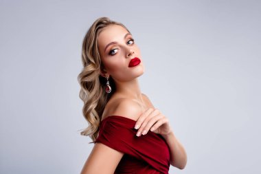 Kıvırcık sarı saçlı, güzel bir bayan şenlik için kırmızı elbise giyiyor..